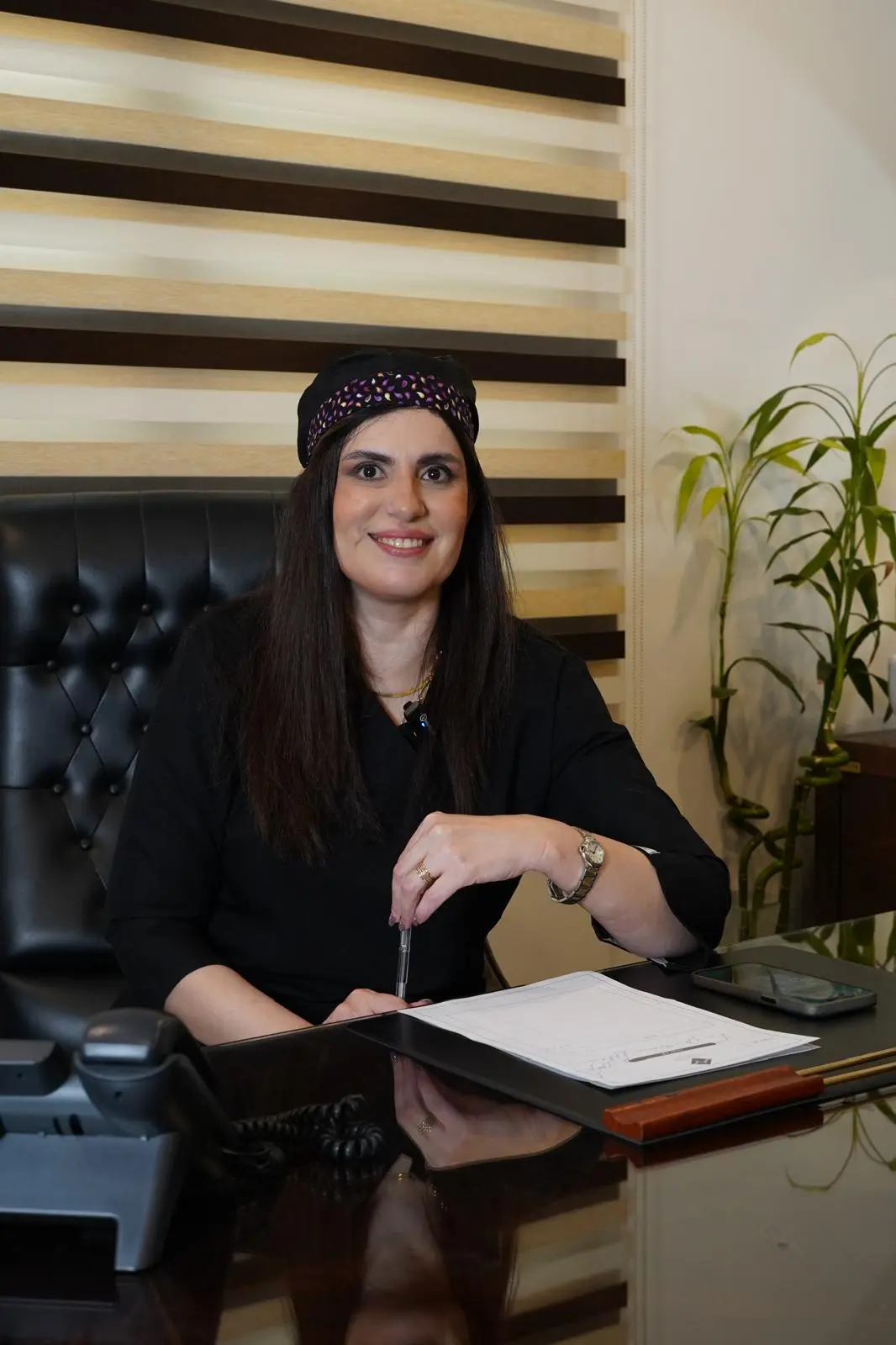 Dr. Roxanna Sadoughifar seated at her desk at our hair transplant clinic in Tehran, Iran.